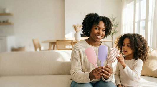 Mère montrant trois brosses démêlantes adaptées aux cheveux texturés de sa fille souriante - Guide de choix
