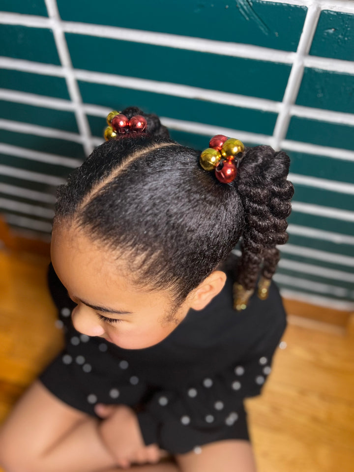 Petite fille métissée avec une coiffure protectrice dont les sections sont attachées avec des élastiques boules