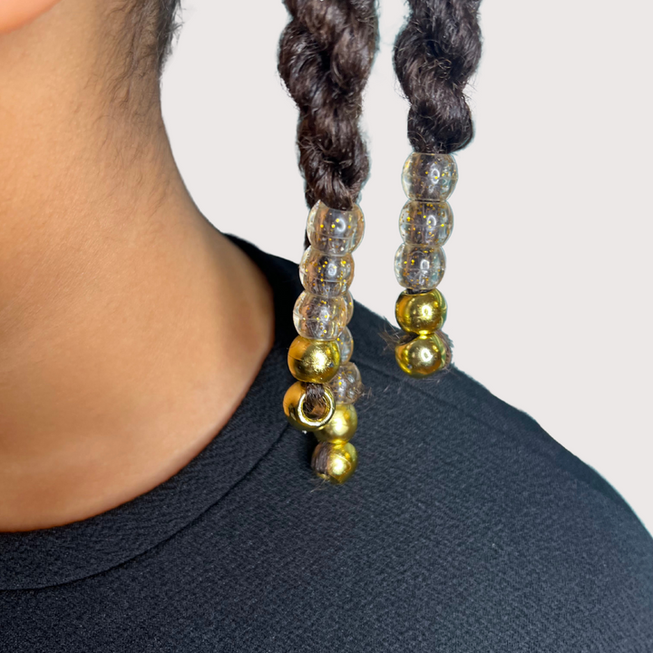 Perles dorées sur coiffure protectrice enfant cheveux texturés