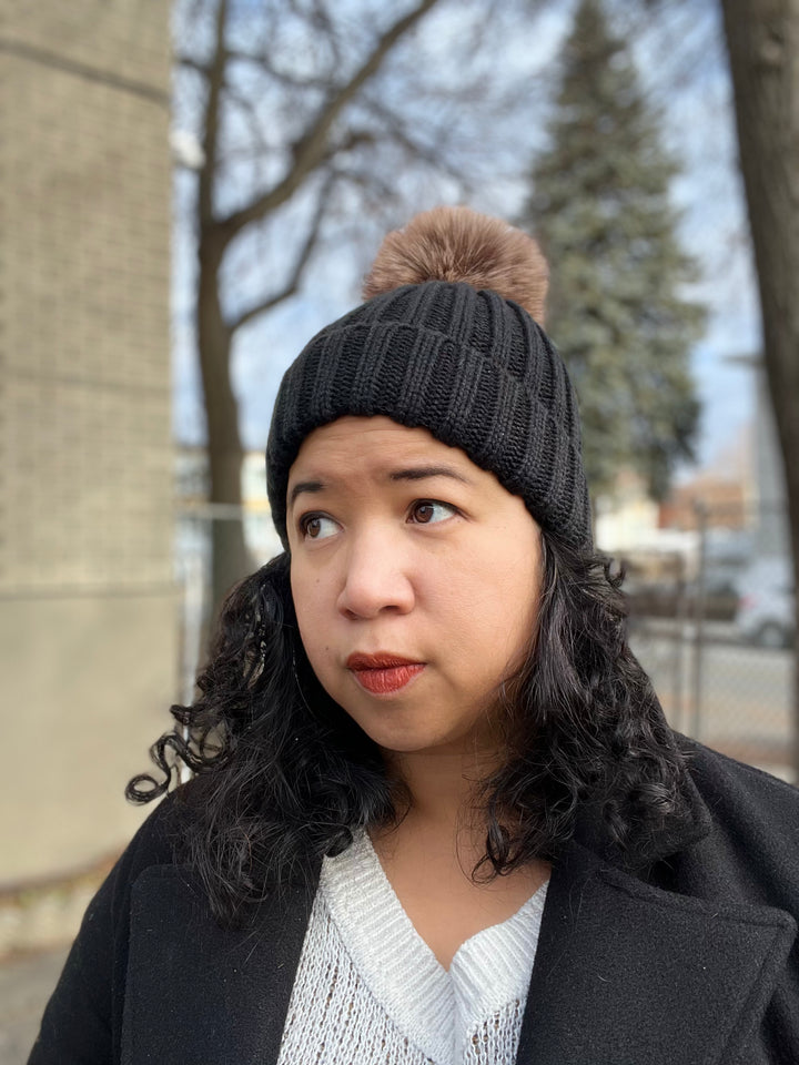 Bonnet d’hiver noir avec doublure satinée et pompom amovible pour cheveux texturés.