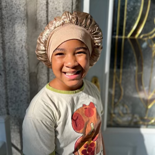Enfant portant un bonnet en satin doré Serenity Night