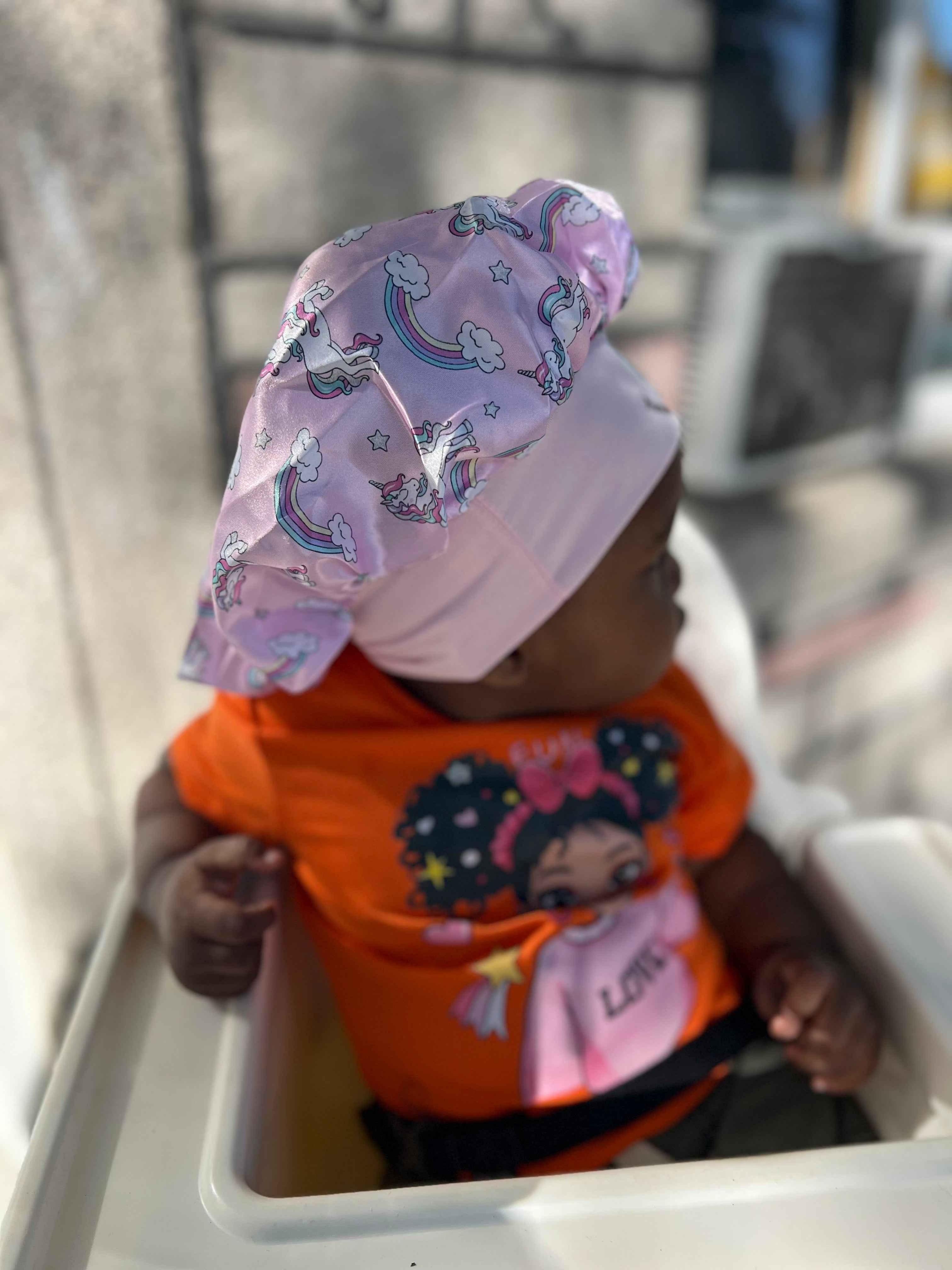 Bonnet en satin licorne adapté aux cheveux crépus d’un enfant