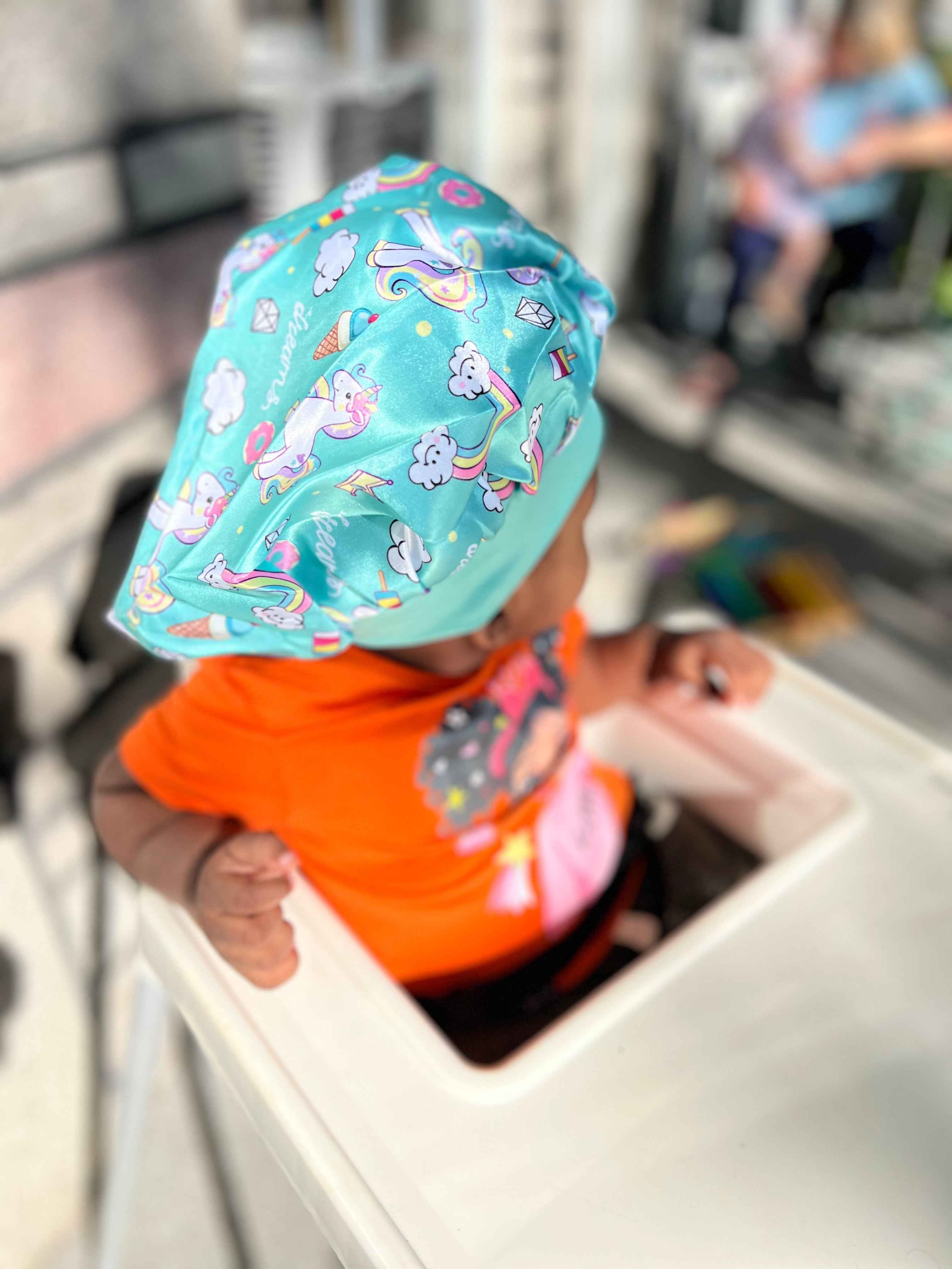 Détail du motif licorne du bonnet en satin enfant