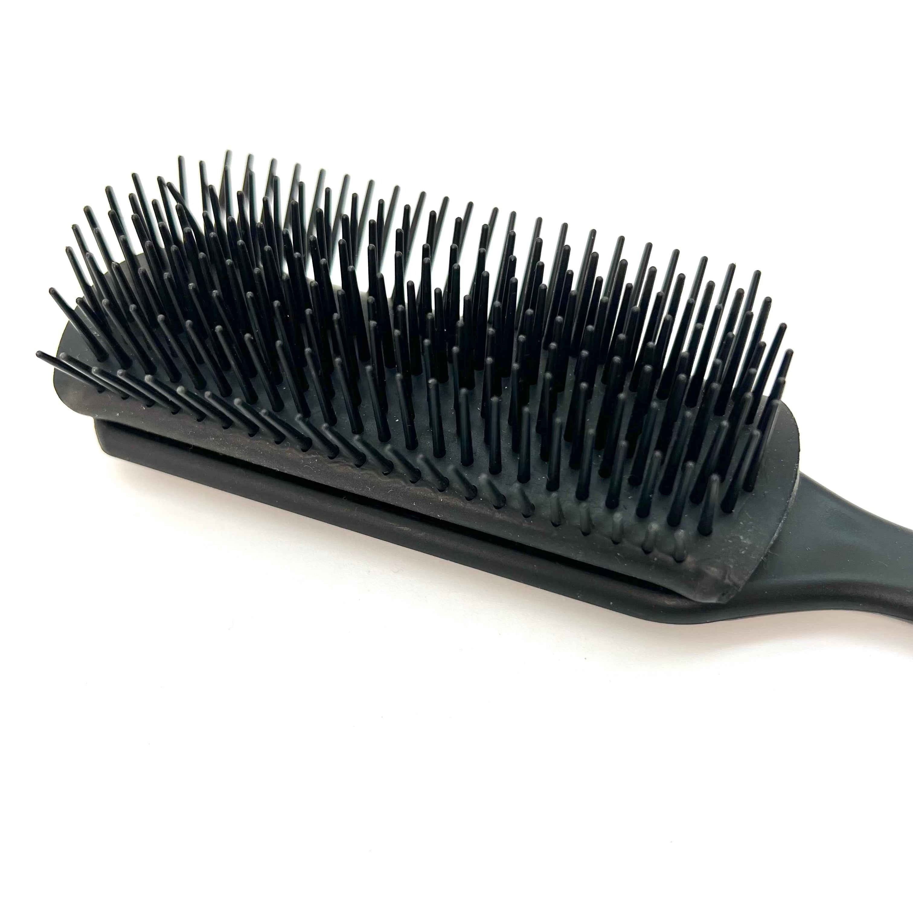 Démêlage doux des cheveux frisés avec la brosse Frisette