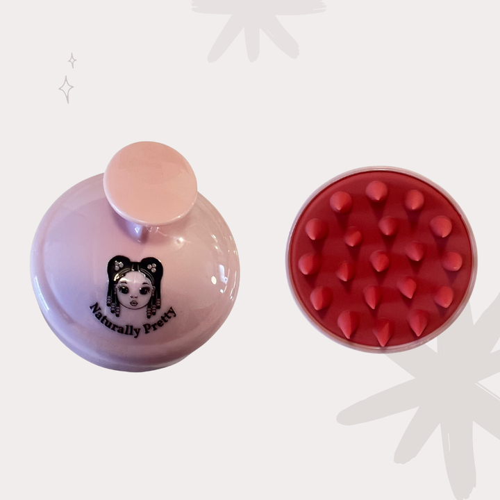 Brosse massante rose pour activer la pousse et masser en douceur le cuir chevelu des enfants aux cheveux texturés.