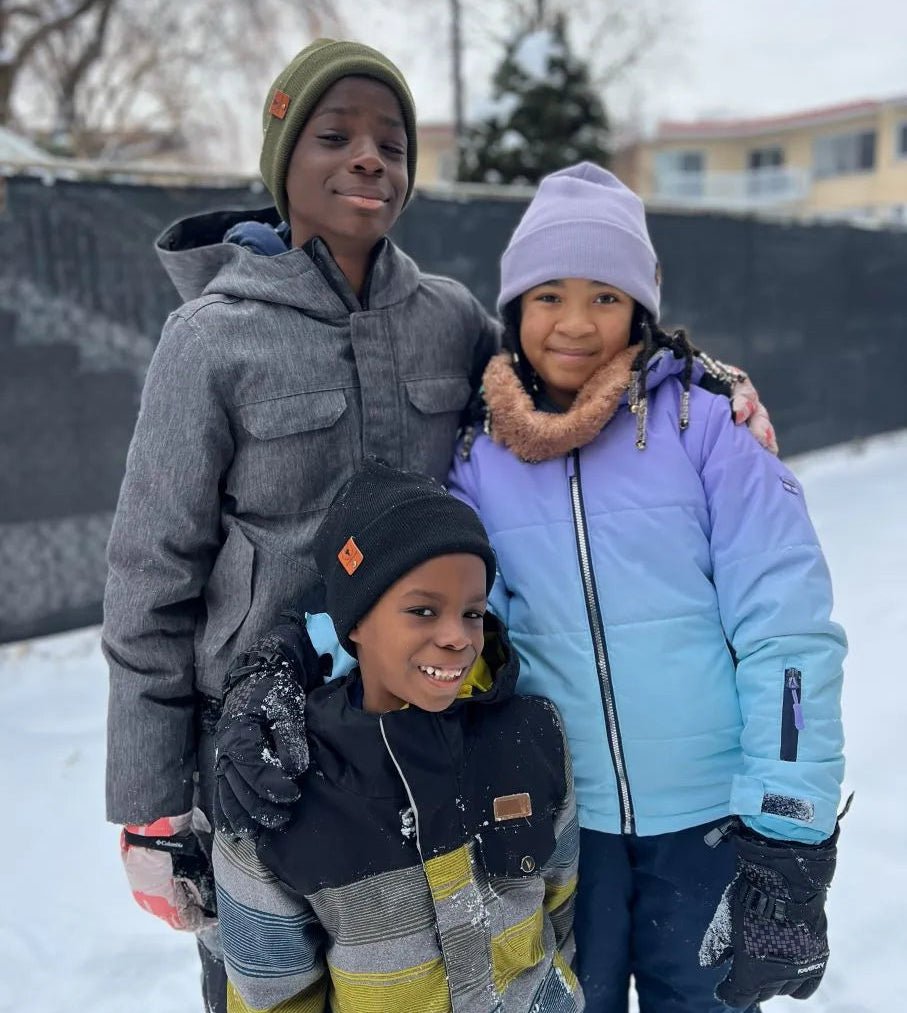 Groupe d'enfants avec des bonnets d'hiver avec intérieur satin protégeant leurs tresses et cheveux frisés du froid intense.