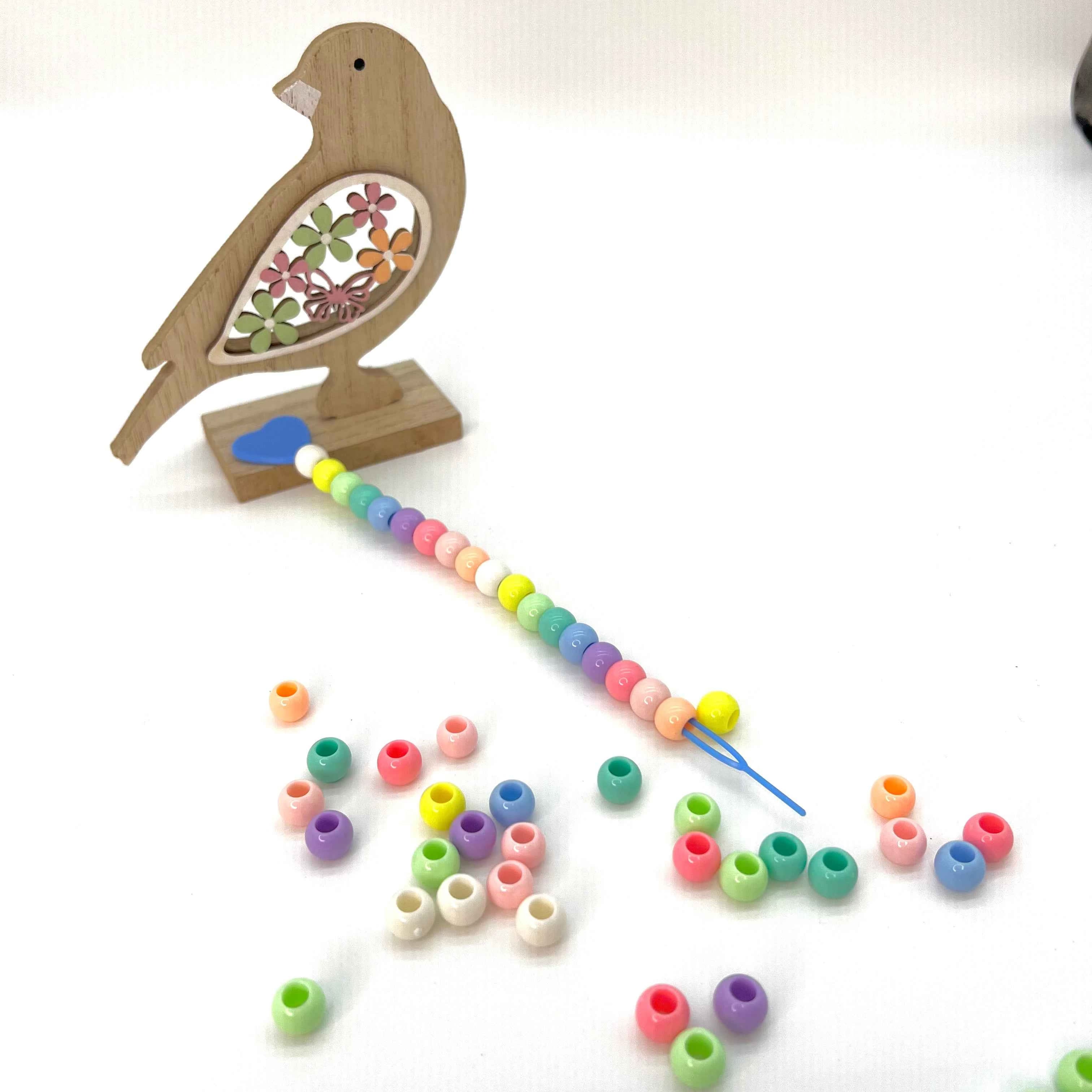 Enfile-perles pour ajouter des perles aux cheveux frisés d’une petite fille