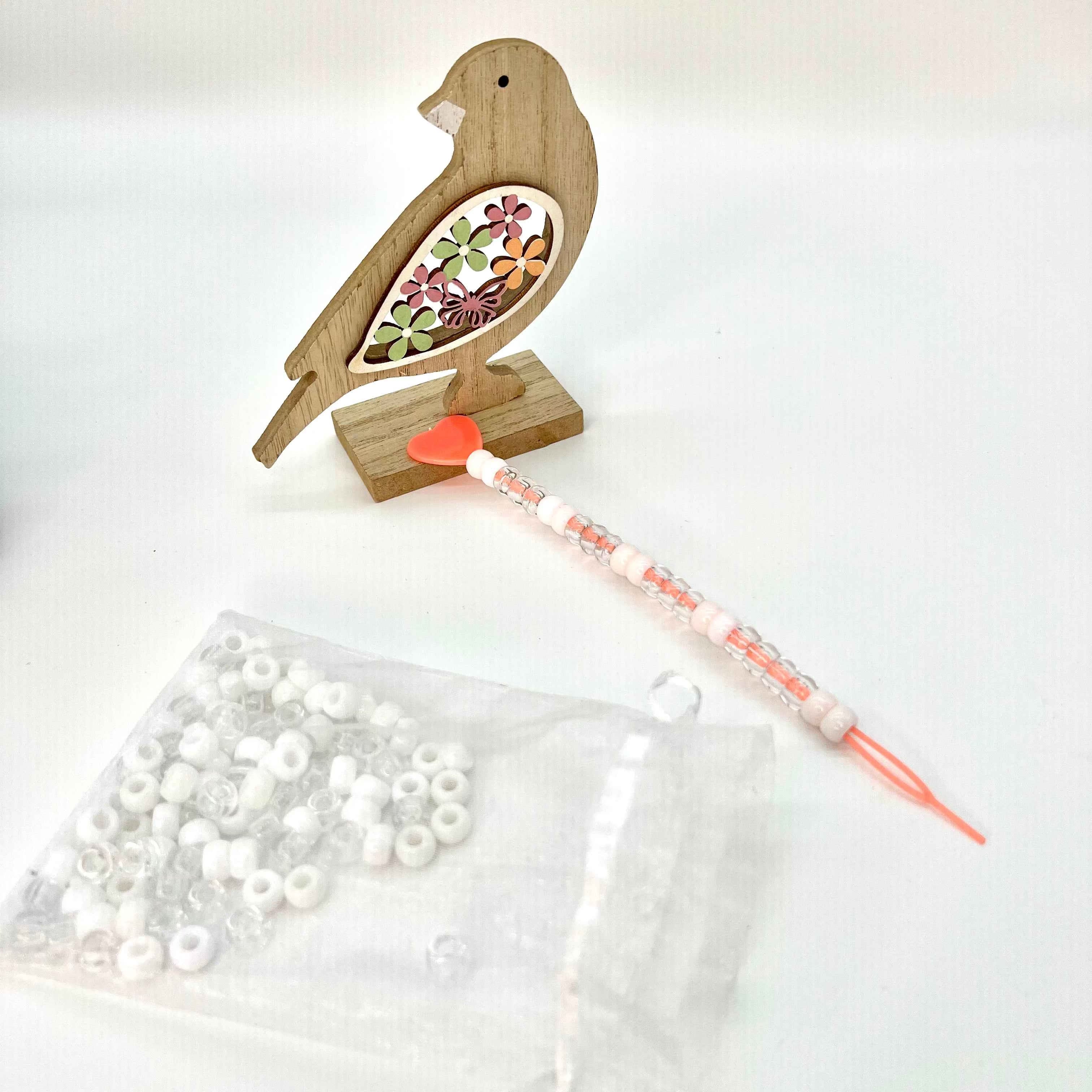 Ajout de perles sur les cheveux texturés d’une petite fille métisse