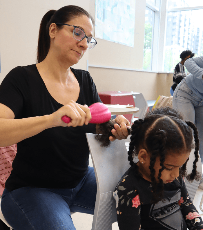 Maman blanche qui apprend a coiffer sa fille metisse de 3 ans 