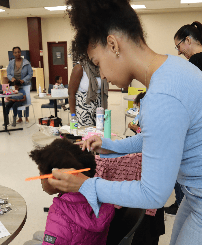 Une maman qui apprend à coiffer son enfant aux cheveux crépus