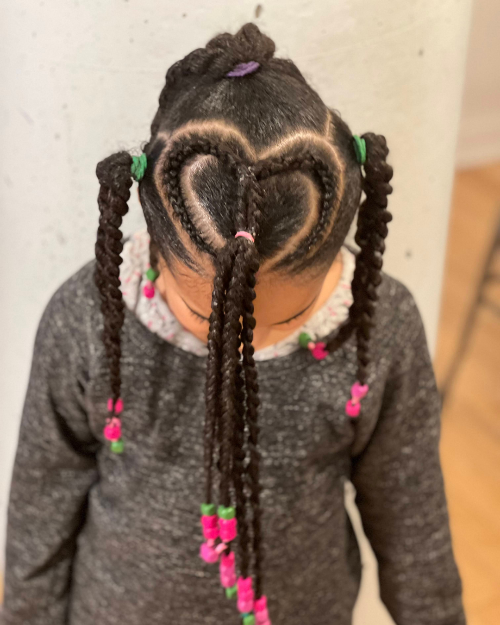 Coiffure enfant avec twists en forme de cœur et perles roses et vertes sur cheveux crépus